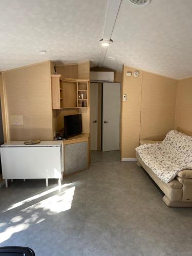 Cette chambre comprend un lit, un bureau et une cuisine. dans l'établissement Mobil home 42 m2 europcamping, à Fréjus