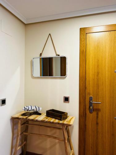 a mirror on a wall next to a wooden table at MARINA LLANES V in Llanes
