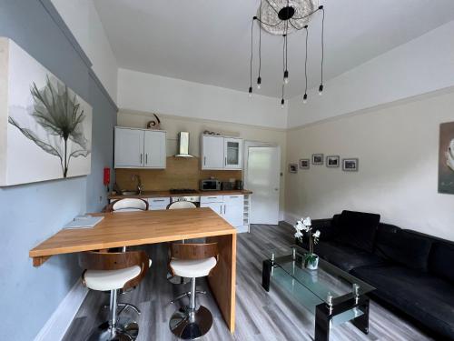 uma cozinha e sala de estar com uma mesa de madeira e cadeiras em The George Centre em Matlock