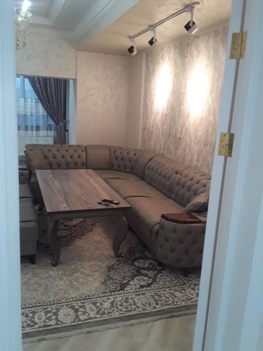 a living room with a couch and a wooden table at Apartment in Fergana