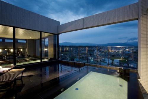a swimming pool on the roof of a building at Candeo Hotels Ozu Kumamoto Airport in Ozu