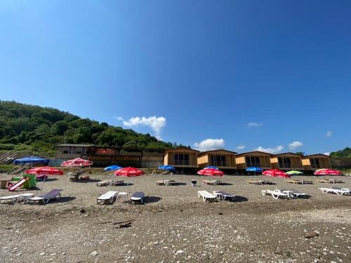 eine Gruppe von Stühlen und Sonnenschirmen am Strand in der Unterkunft Black Sea Beach Bungalow in Akcakoca