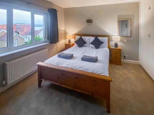 a bedroom with a bed with two pillows on it at Sea View Cottage in Llandrillo-yn-Rhôs