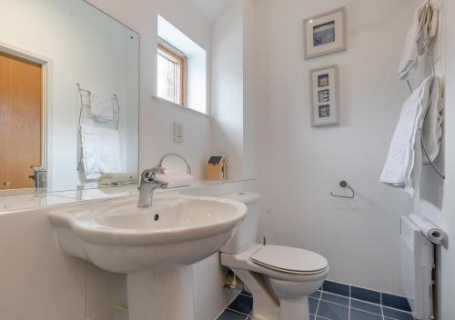 Baño blanco con lavabo y aseo en 6 St Elvans, en Porthleven