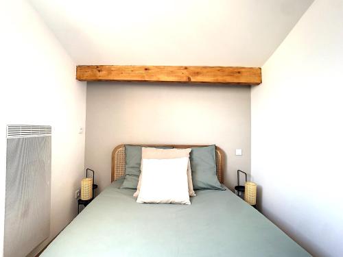 een kleine slaapkamer met een bed met een houten hoofdeinde bij Appartement 3 chambres à proximité des plages in Cannes