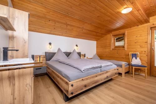 a bedroom with a bed and a sink and a tub at Almstüberl - Schiestl's Ferienhütten in Mayrhofen