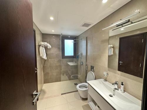 y baño con lavabo, aseo y ducha. en Apartment in Hawana,Rotana en Ma‘mūrah