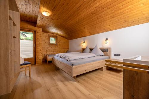 - une chambre avec un lit et un plafond en bois dans l'établissement Schiestl's Almstüberl, à Mayrhofen