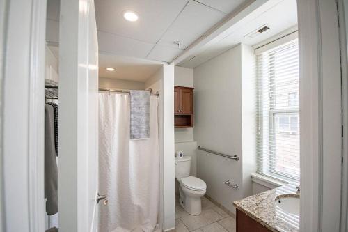 baño con ducha y aseo y ventana en Unique 1 BR 1BA Stay in Downtown - 204 en Champaign