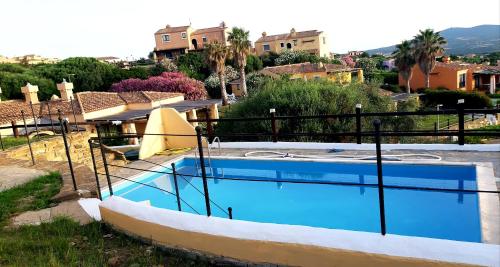 a large swimming pool in a yard with houses at Casa Ethno Stintino-Private pool in Stintino