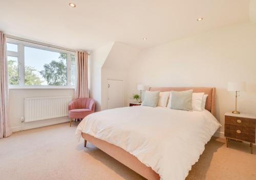 a white bedroom with a large bed and a window at The Willows in Bromeswell