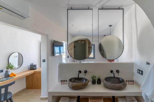two sinks in a bathroom with two mirrors at Enalios sunset suites in Naxos Chora