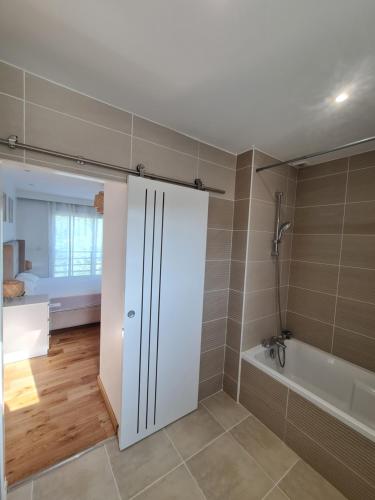 a bathroom with a white cabinet and a bath tub at Charmante Villa moderne in Pornichet