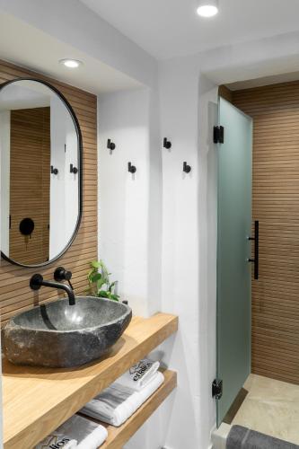 a bathroom with a sink and a mirror at Enalios sunset suites in Naxos Chora