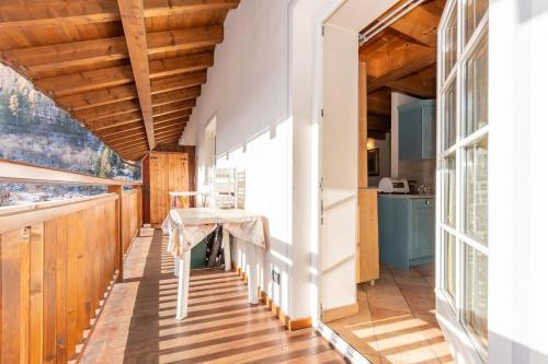 a dining room with a table and a kitchen at Appartamento Mazzini in Predazzo