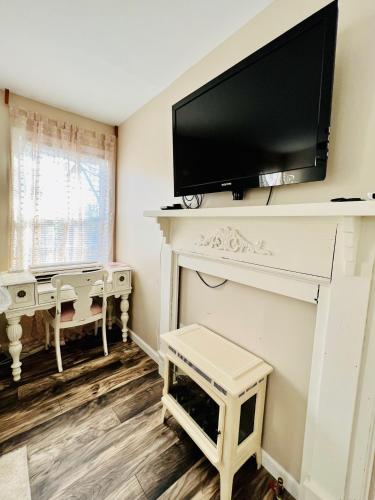 a living room with a fireplace with a tv above it at Coastal Casita by the River in New Bern