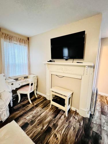 a living room with a tv on top of a fireplace at Coastal Casita by the River in New Bern