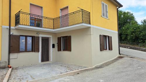 a yellow and white house with a balcony at "Casa Vacanza Greci" in Greci