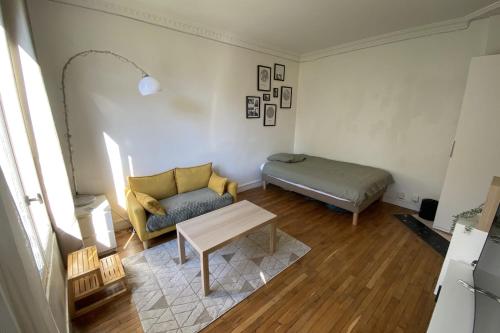 ein Wohnzimmer mit einem Sofa und einem Bett in der Unterkunft Cozy love nest near the Seine in Issy-les-Moulineaux