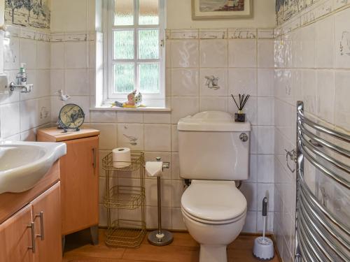 a bathroom with a toilet and a sink at The Old Thatch in Hailsham
