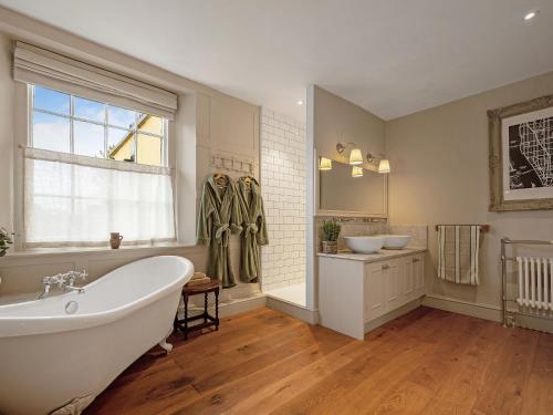 莫頓因馬什的住宿－Cotswold House，带浴缸和盥洗盆的大浴室