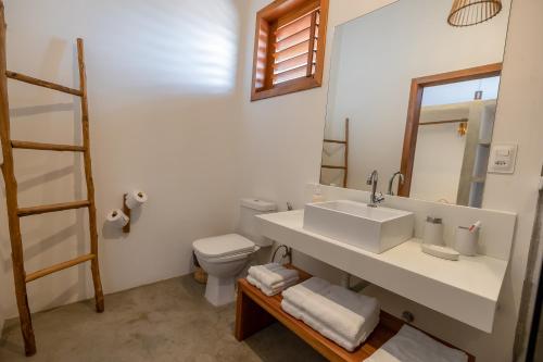 La salle de bains est pourvue d'un lavabo, de toilettes et d'un miroir. dans l'établissement Villa Binn by Kabana, à Prea