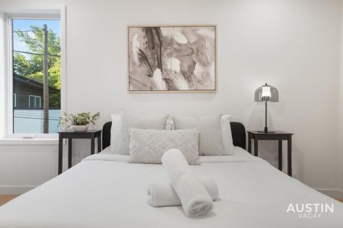 a white bedroom with a large white bed with white pillows at Walk to Soco Lounge Poolside at Modern Cool Spot in Austin