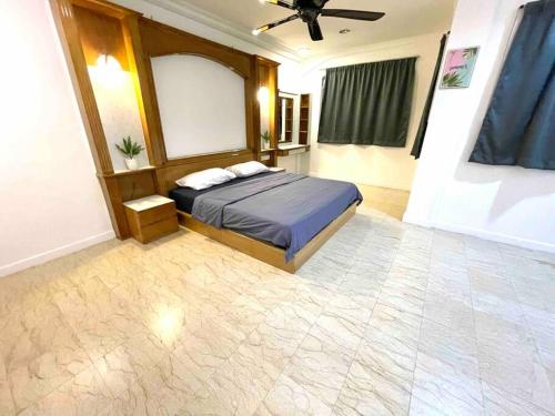 una camera da letto con un letto e un ventilatore a soffitto di 6-10 Pax @ The CoZySpacious House - Heart Of Sunway a Petaling Jaya