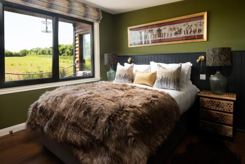 a bedroom with a large bed with a furry blanket at Bastle Retreats Cabin with hot tub in Duns
