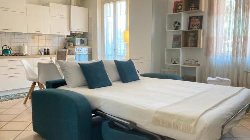 uma cama grande com almofadas azuis numa cozinha em Your Place By The Lake - near Leonardo Academy, MXP em Sesto Calende