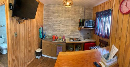 a small kitchen with a counter and a clock on the wall at Suite Matrimonial 2 Rocas del Mar in Pichilemu