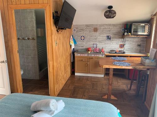a small kitchen with a table and a sink at Suite Matrimonial 2 Rocas del Mar in Pichilemu