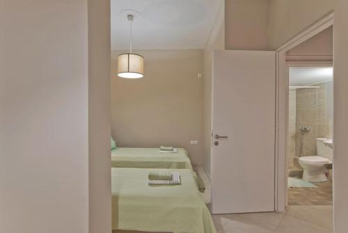a room with two beds and a bathroom with a toilet at Filoxenia in athens in Athens