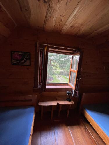 una habitación con 2 bancos y una ventana en una cabaña en Domek Na Roztoczu, 