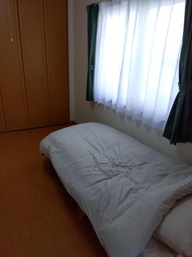 a white bed in a room with a window at Restful Tsukuda - Vacation STAY 14829 in Aomori