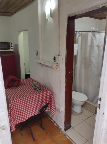 a small bathroom with a table and a toilet at Amanecer campestre junto al Ceibo. in Burzaco