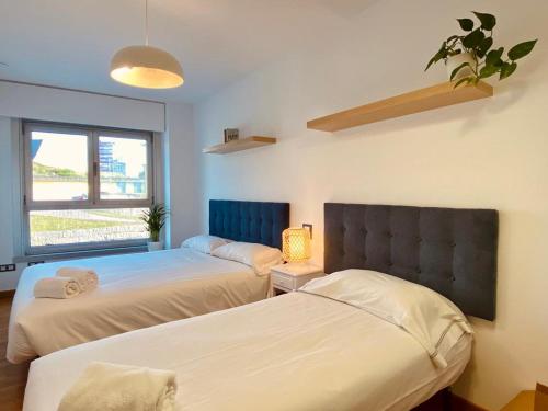 1 dormitorio con 2 camas y ventana en Blue Ocean Apartment, en A Coruña