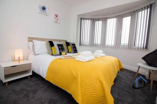 Wheatley Casa, 3 bed, driveway, workspace, wifi, corporates,pets في دونكاستير: غرفة نوم بسرير كبير مع بطانية صفراء