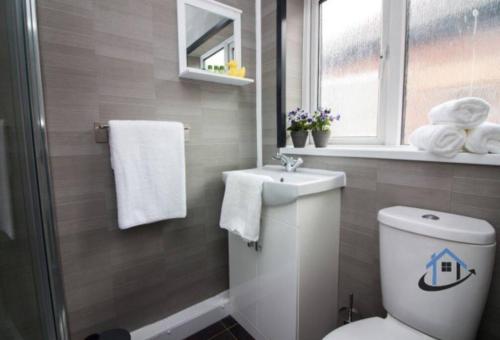 a bathroom with a toilet and a sink and towels at Wheatley Casa, 3 bed, driveway, workspace, wifi, corporates,pets in Doncaster