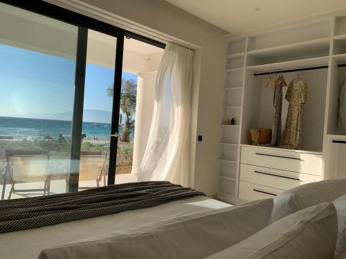 a bedroom with a bed and a view of the ocean at Ayïa suites in Alikanas