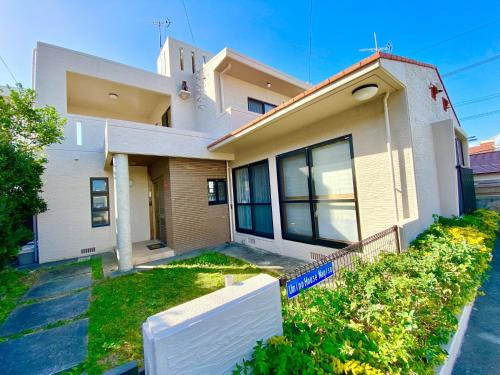 a house with a white fence in front of it at Umino House Nagisa - Vacation STAY 95985v in Nanjo
