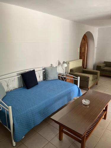 um quarto com uma cama, uma mesa e um sofá em Errika's home near Athens Airport em Spata