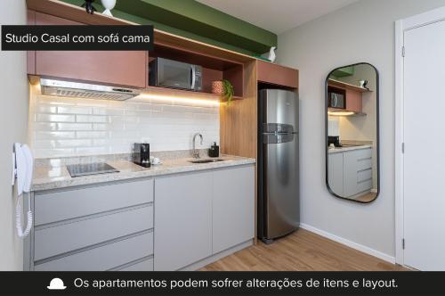 a kitchen with white cabinets and a stainless steel refrigerator at Charlie For You Vila Mariana in Sao Paulo