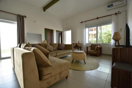 a living room with a couch and a table at The Coco Villa, Garden View Bungalow in Fumba Town in Fumba