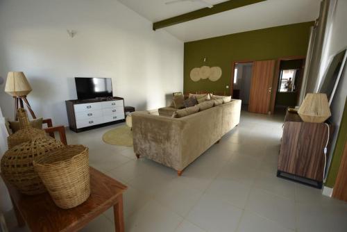 salon z kanapą i telewizorem w obiekcie The Coco Villa w mieście Fumba