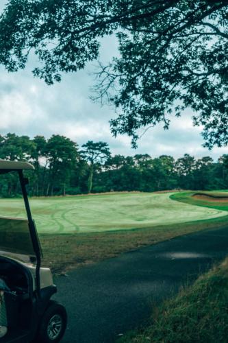 a golf cart parked on the side of a golf course at The Villages at Ocean Edge Resort & Golf Club in Brewster