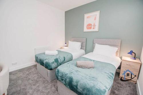 a bedroom with two beds and a night stand at Balby Casa king beds parking workspace wifi corporates pets in Balby