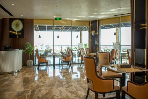 STwin Hotel في أبها: مطعم فيه كراسي وطاولات ونوافذ
