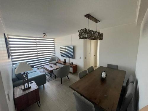 a living room with a table and a dining room at Acogedor departamento centro Iquique in Iquique