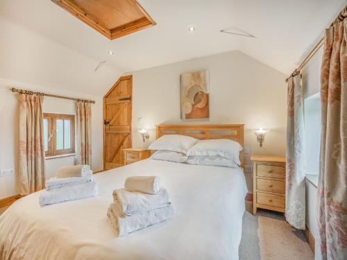 a bedroom with a large white bed with towels on it at The Forge - Uk44517 in North Thoresby